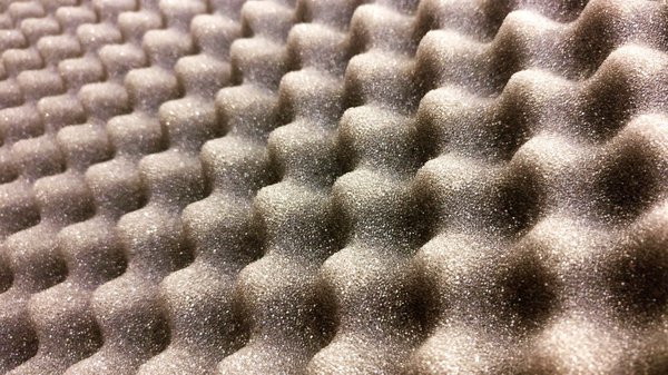 What are the most effective ways to soundproof a shared wall in a UK flat?